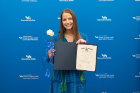 A student receives her Alpha Eta Honor Society membership certificate. 