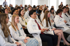 After receiving their white coats, physical therapy students listen to remarks. 