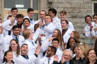 Students celebrate on the steps of Hayes Hall wearing their new white coats. 