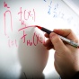 Equations being written on a whiteboard. 