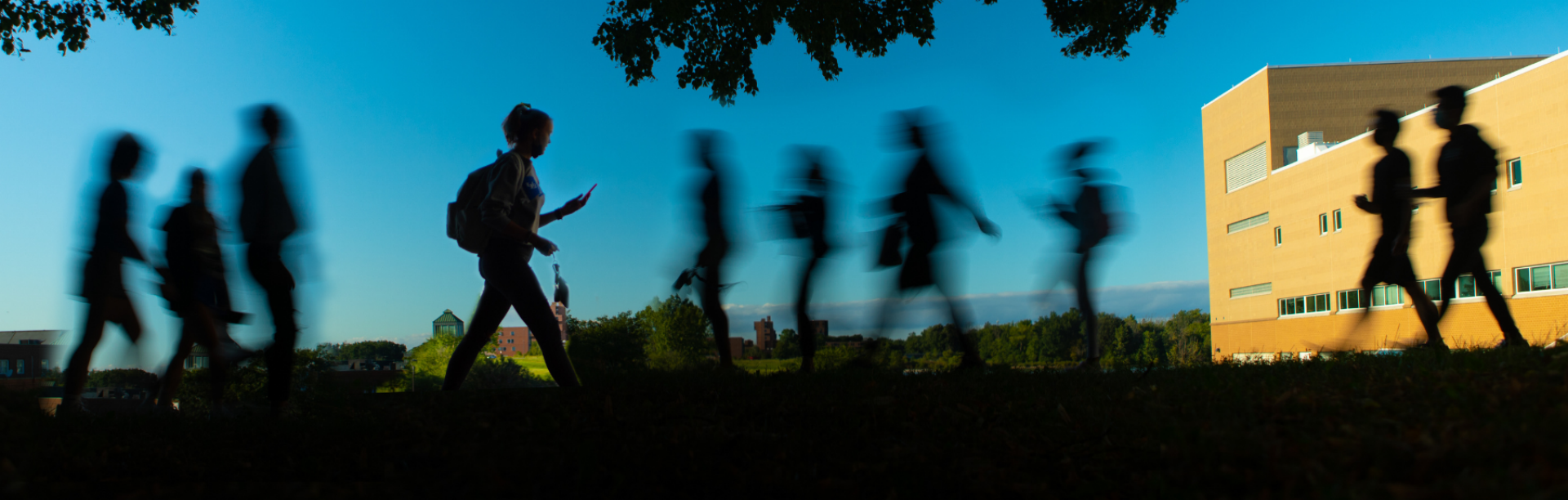 People walk on North Campus near Slee Hall and the Center for the Arts on an evening in September 2021.