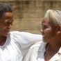 Two African American women smiling at each other. 