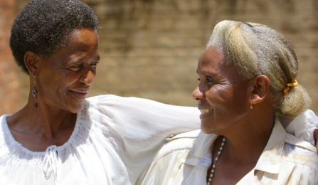 Two African American women smiling at each other. 