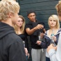 A group of teenagers smoking cigarettes and drinking alcohol. 