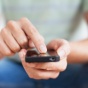 A person placing their finger on their smart phone screen. 