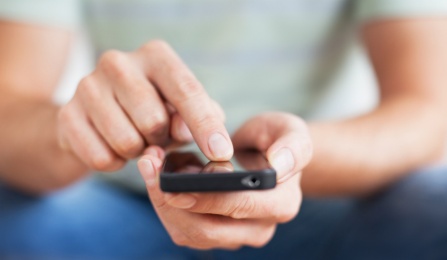 A person placing their finger on their smart phone screen. 