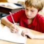 Child writing in a notebook at school. 