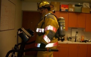 Zoom image: firefighter in work gear walking on a treadmill