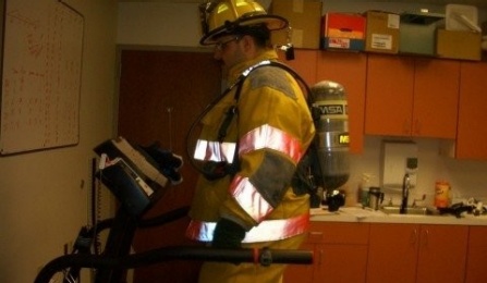 firefighter in work gear walking on a treadmill. 