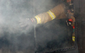 firefighter opening window in smoking building. 