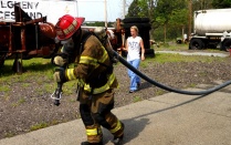 Zoom image: Firefighter pulling hose.
