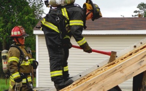 firefighter axing wood wall. 