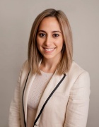 Photograph a woman with shoulder length blonde hair dressed in white business attire. 