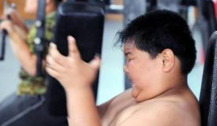 An overweight child performing a strengthening exercise. 