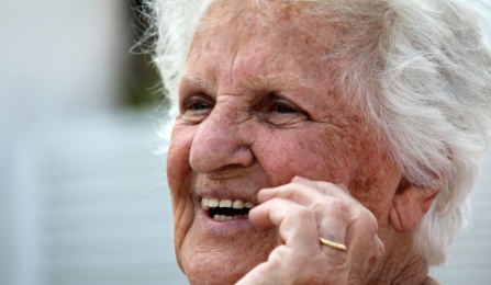 An elderly woman smiling. 