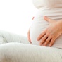 A woman holding her pregnant belly. 