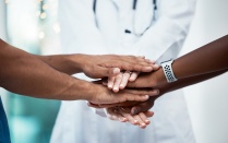 Health experts putting their hands in together. 