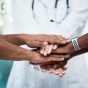 Health experts putting their hands in together. 