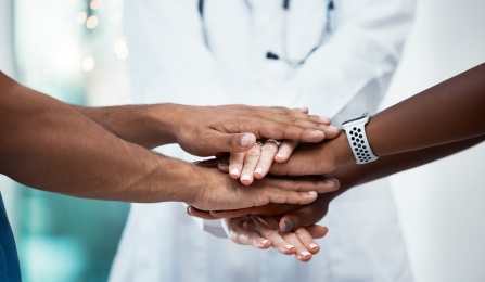 Health experts putting their hands in together. 