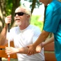 A nurse helping a blind man sit on a bench. 