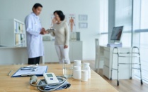 A doctor talking to a patient in a doctors office. 