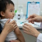 A doctor giving a vaccine to an infant. 