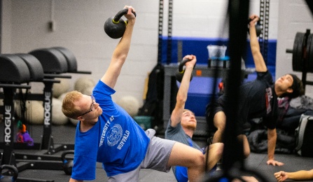 Students learn about kettle ball exercises in Kimball Tower as part of the exercise science program. 