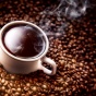Photo of a cup of coffee and coffee beans. 