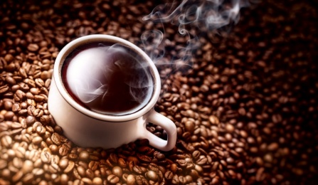 Photo of a cup of coffee and coffee beans. 