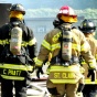 Firefighters entering a smoking building. 