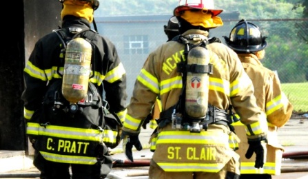 Firefighters entering a smoking building. 