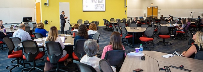 A speaker addresses attendees of a refugee health summit. 