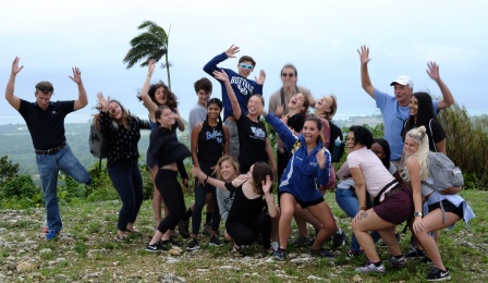 Professor and students in a group photo taken at a park in Jamaica. 