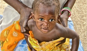 Adult holding a child in Uganda. 