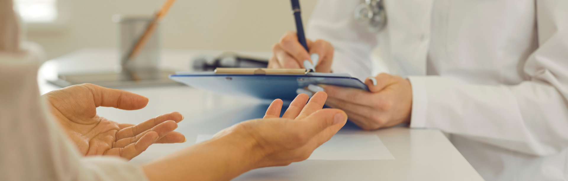 Female doctor with clipboard listening to patient and writing down her health complants. 