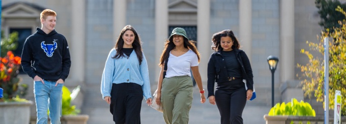 Students walking down sidewalk. 