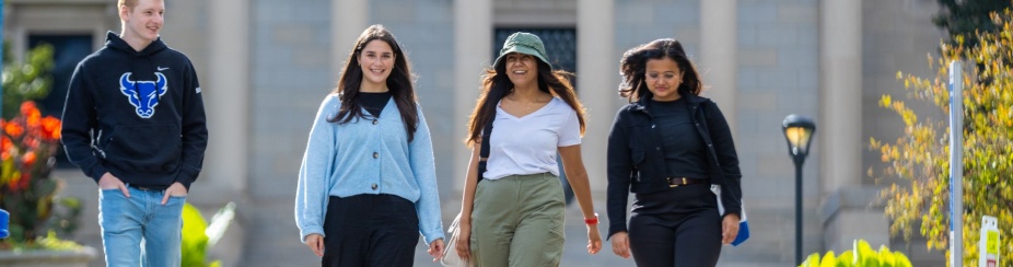 Students walking down sidewalk. 