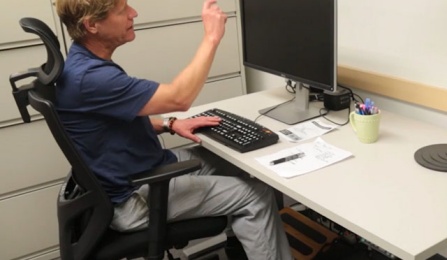 Jim Lenker demonstrates an electric sit-stand desk. 