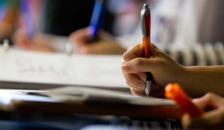 student writing in a classroom. 