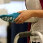 Student demonstrating how to put on a sock in an occupational therapy lab. 