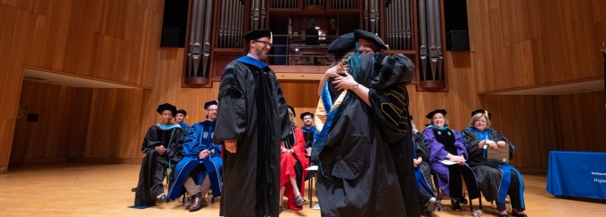 UB Facultyand Alumni hooding a Student on stage at the annual Hooding Ceremony in Slee Hall. 
