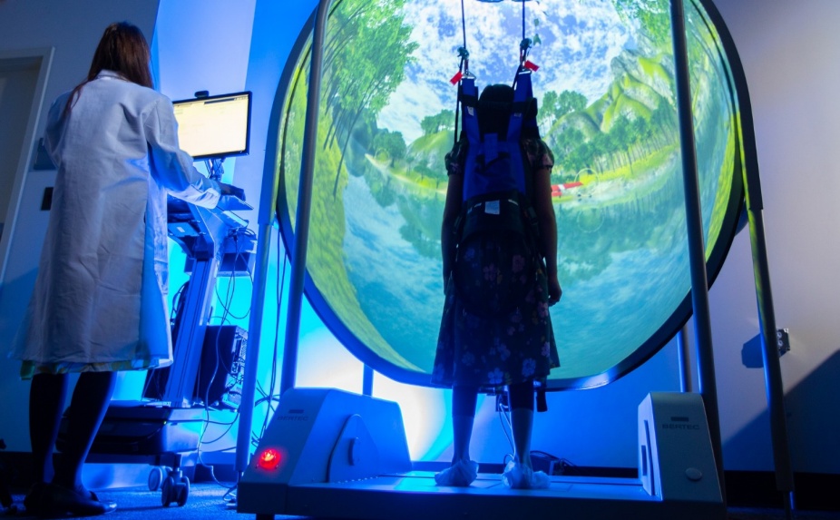 Rehabilitation Science Assistant Professor Ghazala Saleem works with a participant on the computerized dynamic posturagraphy equipment in the Brain Function and Recovery Lab in Kimball Hall. 