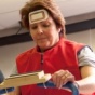 Female volunteer wears a cooling vest while riding a stationary bike. 