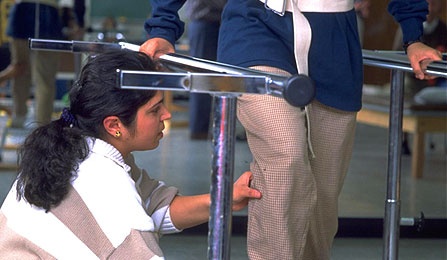 A female student assisting with a physical therapy technique. 