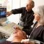 Ultrasound being performed by doctor and nurse on carotid artery of a patient. 