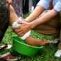 Public health worker washing feet of a citizen in a third world country. 