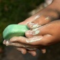 A child cleaning their hands with a bar of soap. 